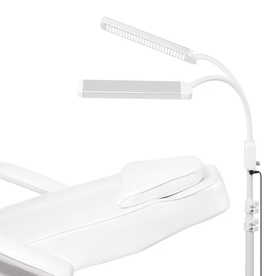White ELITE X LED beauty light beside a lash treatment bed, treatment bed scene, lash treatment setup