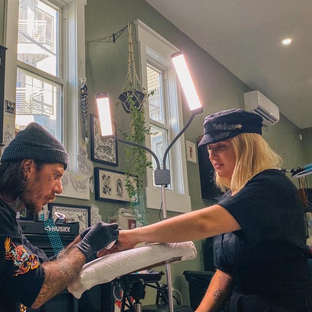 Tattoo artist utilizing the Elite X Floor Light Kit for high-definition, consistent lighting.