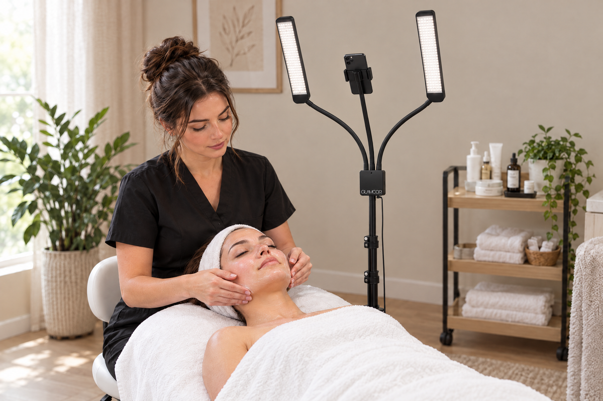 Esthetician giving a facial on a treatment bed, with the MULTIMEDIA X standing beside the bed